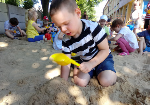 Chłopiec robi babki z piasku